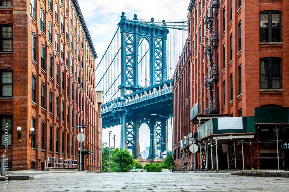 Fototapeta Manhattan Bridge między Manhattanem a Brooklynem nad East River widziany z wąskiej uliczki otoczonej dwoma ceglanymi budynkami w słoneczny dzień na ulicy Washington w Dumbo, Brooklyn, NYC