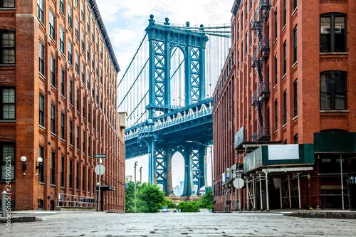 Obraz Manhattan Bridge między Manhattanem a Brooklynem nad rzeką East River widziany z wąskiej uliczki zamkniętej dwoma ceglanymi budynkami w słoneczny dzień na Washington street w Dumbo, Brooklyn, Nowy Jork