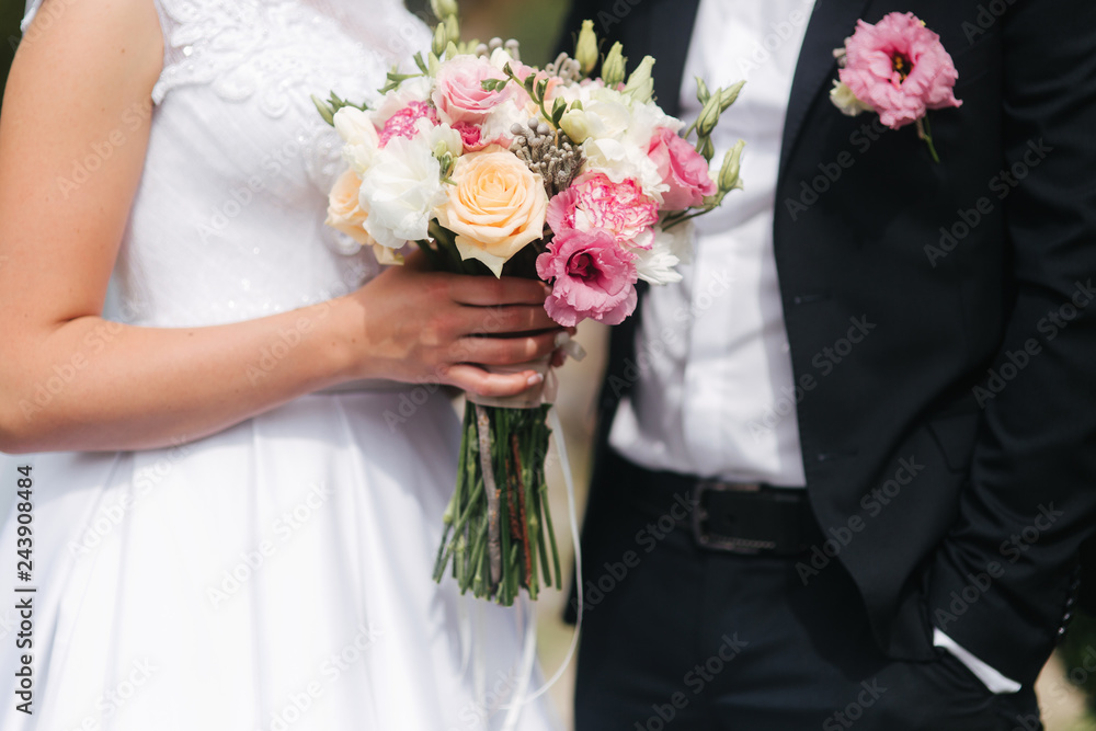 Wedding bouquet in brides hands. Close up view of couples hands holding wedding bouquet. Flowers Wedding bouquet in brides hands. Close up view of couples hands holding wedding bouquet. Flowers