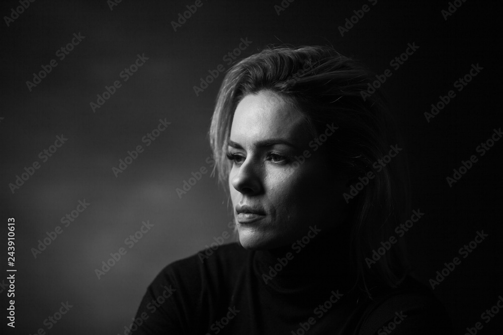 Dramatic black and white portrait of a beautiful woman on a dark background Dramatic black and white portrait of a beautiful woman on a dark background