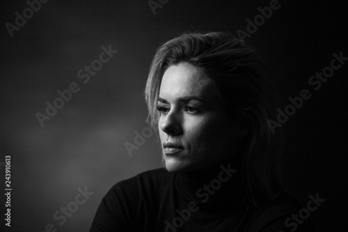 Dramatic black and white portrait of a beautiful woman on a dark background