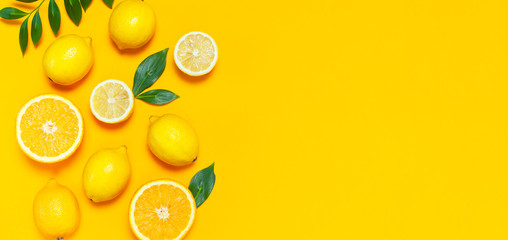 Ripe juicy lemons, orange and green leaves on bright yellow background. Lemon fruit, citrus minimal concept, vitamin C. Creative summer minimalistic background. Flat lay, top view, copy space.