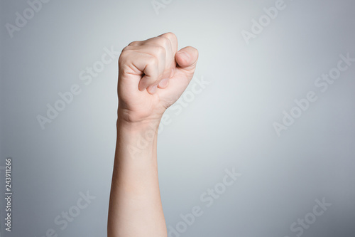 Raised up fist on gray background