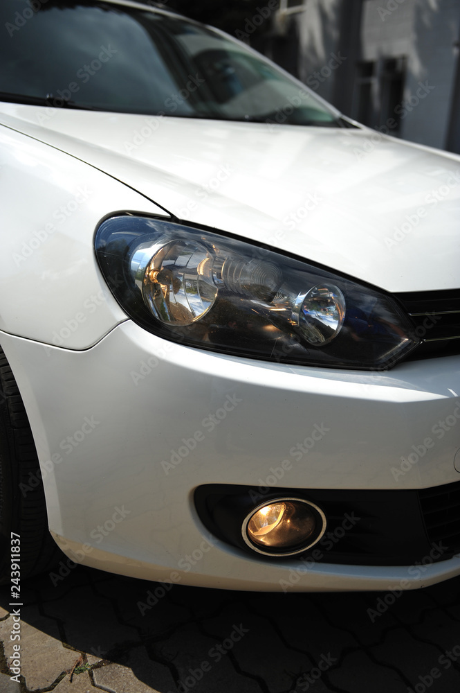 headlight of the main light of the white car, close-up.