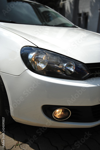 headlight of the main light of the white car, close-up.