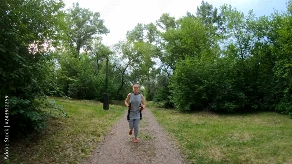 Jogging in the park. Girl running along the forest path. Front view. Slow motion Jogging in the park. Girl running along the forest path. Front view. Slow motion