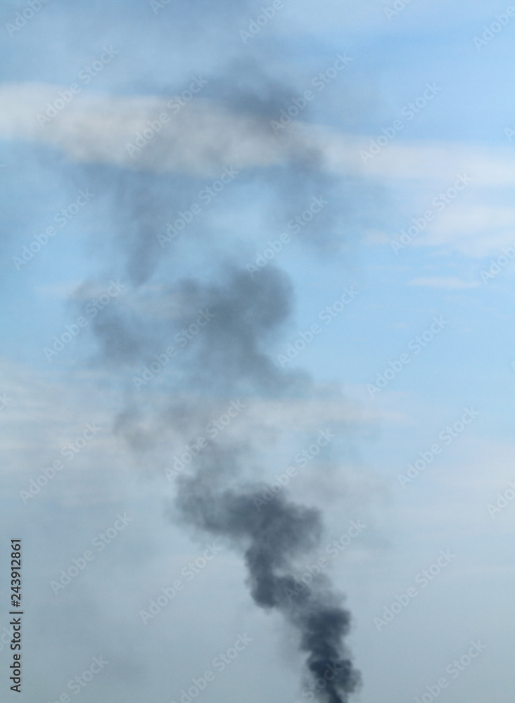Black smoke with blue sky in background