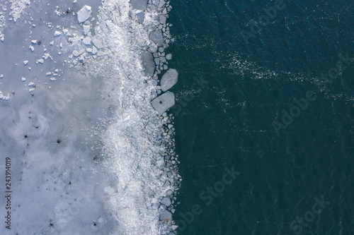 Glacier Lagoon with icebergs from above. Aerial View. Cracked Ice from drone view. Background texture concept. © Curioso.Photography