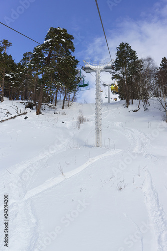 Fototapeta Naklejka Na Ścianę i Meble -  Chairlift in the fir forest in the ski resort