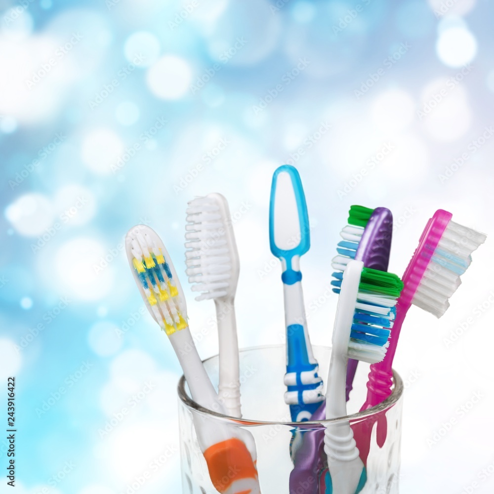New Colorful Toothbrushes in A Glass on Background New Colorful Toothbrushes in A Glass on Background