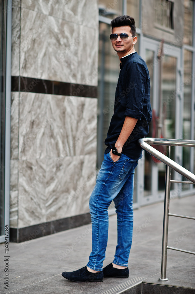 Stylish indian model man in casual clothes and sunglasses posed outdoor at street of India. Stylish indian model man in casual clothes and sunglasses posed outdoor at street of India.