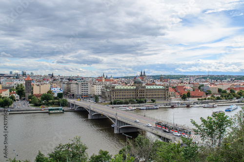 View of the Ministry of Industry of the Czech Republic. Beautiful view of Prague, one of the new bridges. Tram and cars drive over the bridge over the Vltava river. Ship sailing along the river. On th