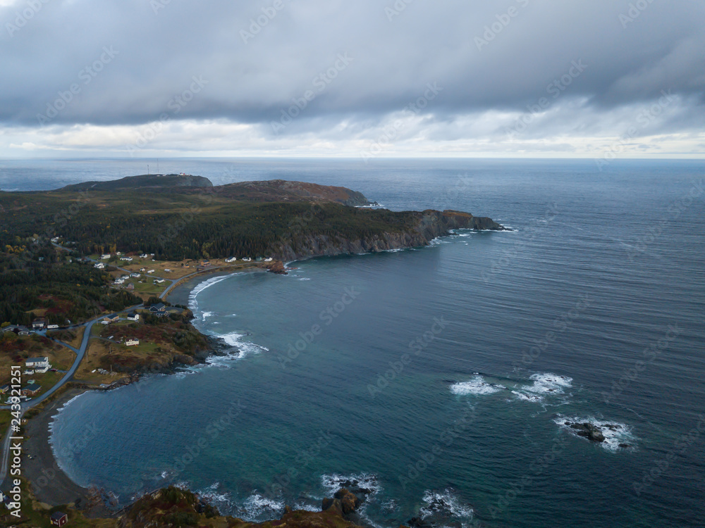 Aerial view of a small town on a rocky Atlantic Ocean Coast during a cloudy day. Taken in Paradise, Twillingate, Newfoundland, Canada.