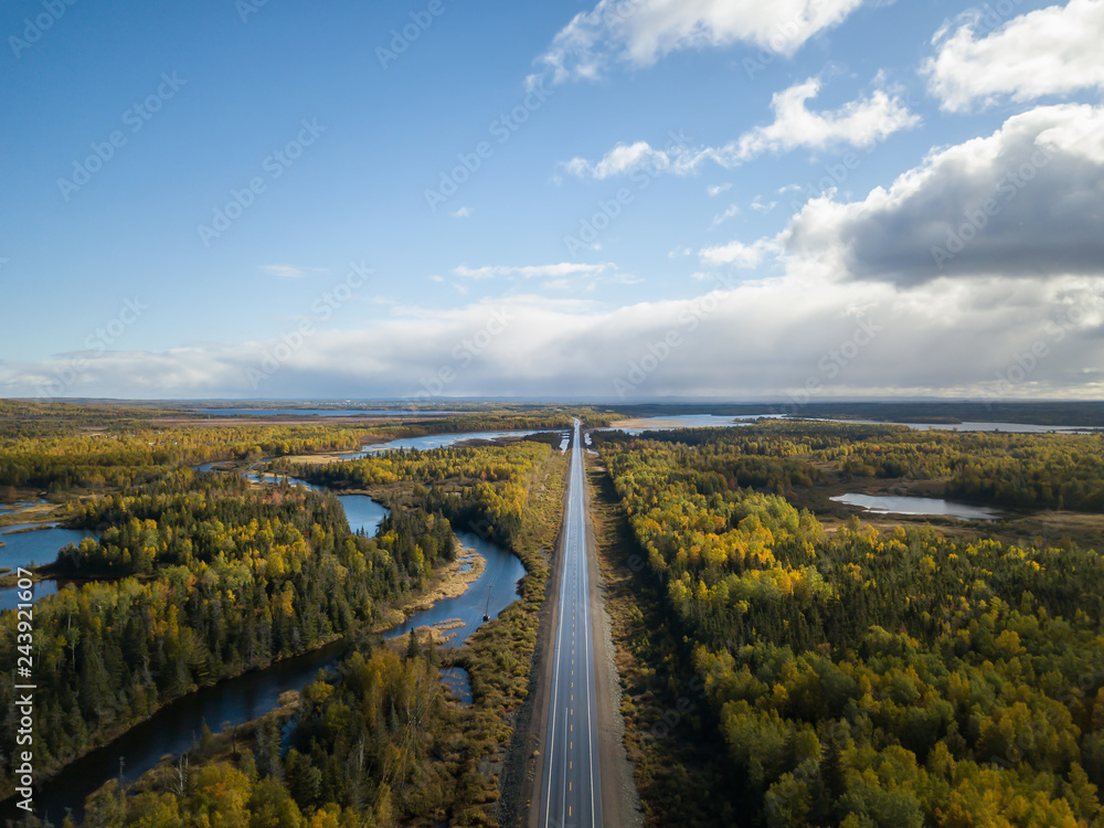 Aerial view of a scenic road during a beautiful sunny day in the Autumn. Taken near Grand Falls-Windsor, Newfoundland, Canada.