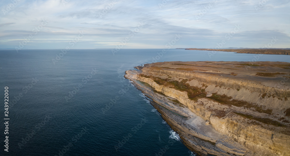 Aerial panoramic view of a rocky Atlantic Ocean Coast during a cloudy sunset. Taken in Burnt Cape Ecological Reserve, Raleigh, Newfoundland, Canada.
