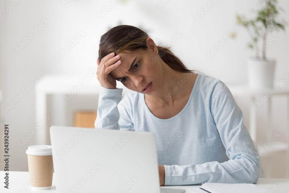 Frustrated woman using laptop, worried about problem, reading bad news online, looking at computer screen, receiving email with debt notification or negative message, feeling depressed Frustrated woman using laptop, worried about problem, reading bad news online, looking at computer screen, receiving email with debt notification or negative message, feeling depressed