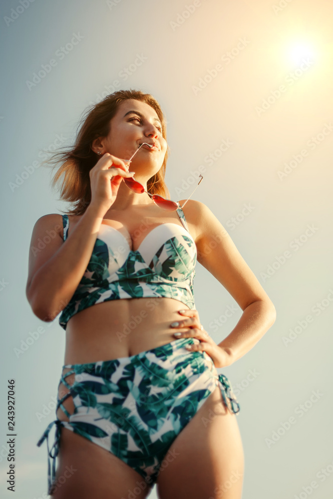 Portrait of a beautiful smiling happy young woman in sunglasses and bikini on the beach. concept of relaxation, recreation. Toned Instagram Portrait of a beautiful smiling happy young woman in sunglasses and bikini on the beach. concept of relaxation, recreation. Toned Instagram