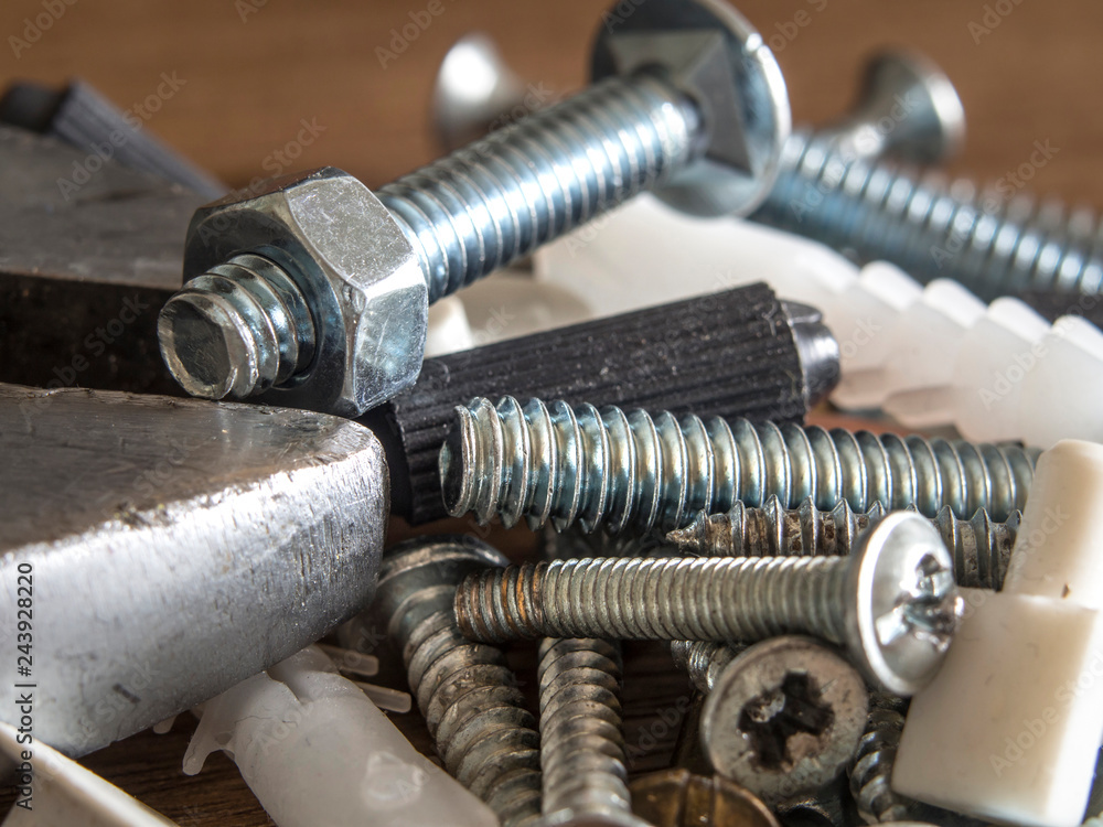 screws and nuts standing on wooden floor in various sizes screws and nuts standing on wooden floor in various sizes