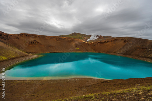 View at Krafla volcanic crater and Viti lake in northern Iceland, vapor of geothermal power plant unit is at background © sasha64f
