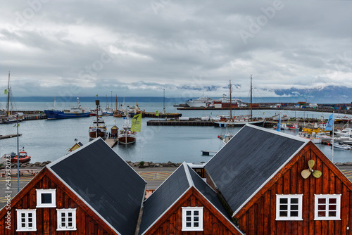 View of the Husavik Port  in Nordurting municipality on the North coast of Iceland. Parts of harbor wooden constructions are at foreground. photo