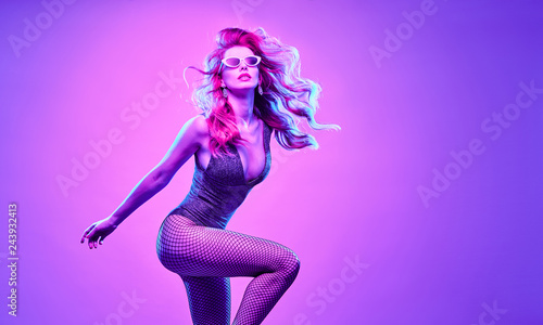 High Fashion. Gorgeous Disco Party girl with glowing hair dance. Young beautiful model woman in Colorful neon Light. Night Clubbing. Stylish fashionable banner