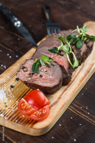 Beef steak on a board with tomatoes and seasonings