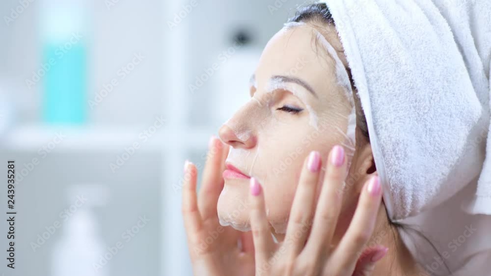 Pretty young woman applying face mask at home. Pretty young woman applying face mask at home.
