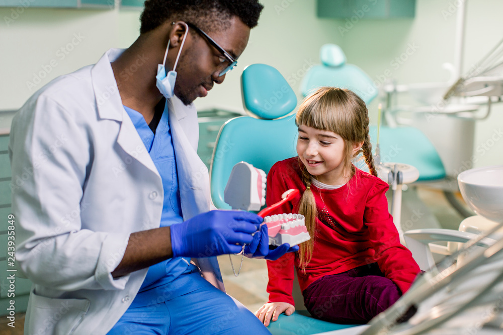 Fototapeta premium Dentist examines baby girl's teeth. Prophylaxis of caries, milk teeth, pediatrics