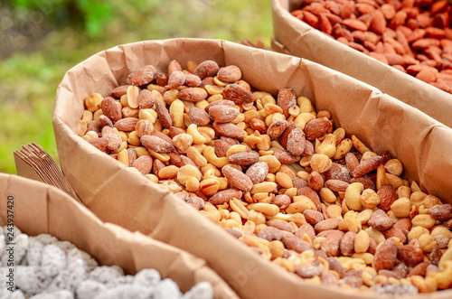 Nuts in sweet shells in paper boxes for sale in the market. photo