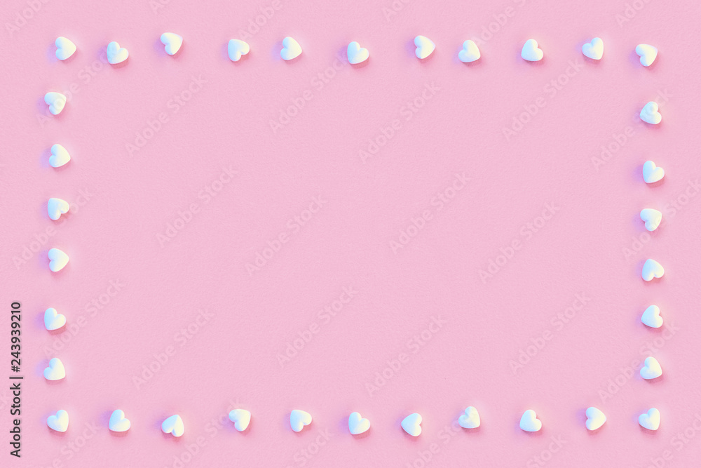 Square frame made of small white sugar candy hearts on a pastel living coral color paper. Rectangle design with copy space for greetings and other text.