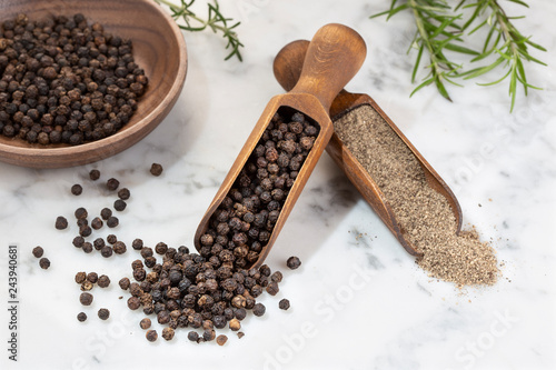 Black pepper seeds and Black pepper ground on marble background. Spices for cooking. Piper nigrum