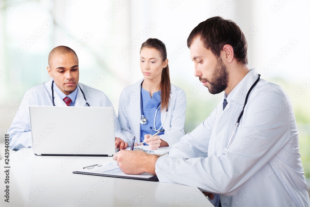 Doctors team talking expertise in hospital by laptop Doctors team talking expertise in hospital by laptop