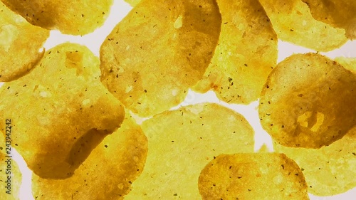 Spicy potato chips spinning on white background, food with flavor intensifiers photo