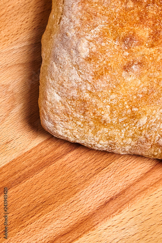 traditional italian wheat bread ciabatta with crispy crust on a wooden table
