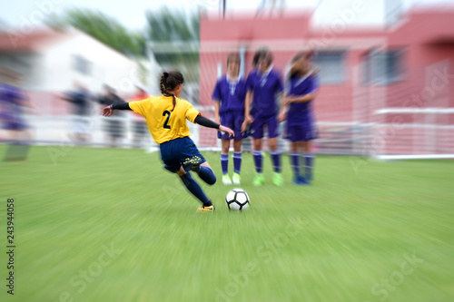 jeune femme jouant au football en plein match © AUFORT Jérome