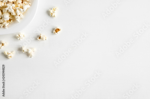 Background with a plate of popcorn. White background with popcorn. Place for inscription