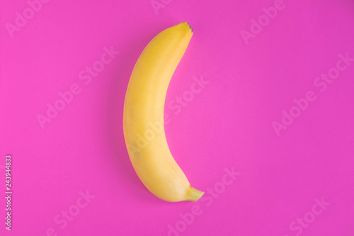 Conceptual photo of a banana on a pink background. Banana photo for advertising. Flat lay, top view.