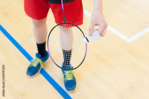Man is holding the shuttlecock and the badminton racket. In sport hall background © Augustas Cetkauskas