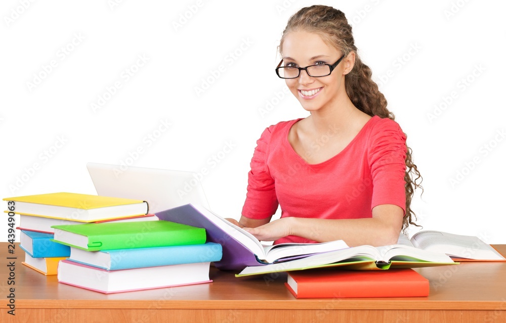 Friendly Girl Sitting Behind a Desk with a Books and Using Friendly Girl Sitting Behind a Desk with a Books and Using