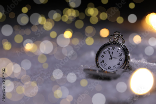 Pocket watch on snow against blurred background, space for text. Winter night