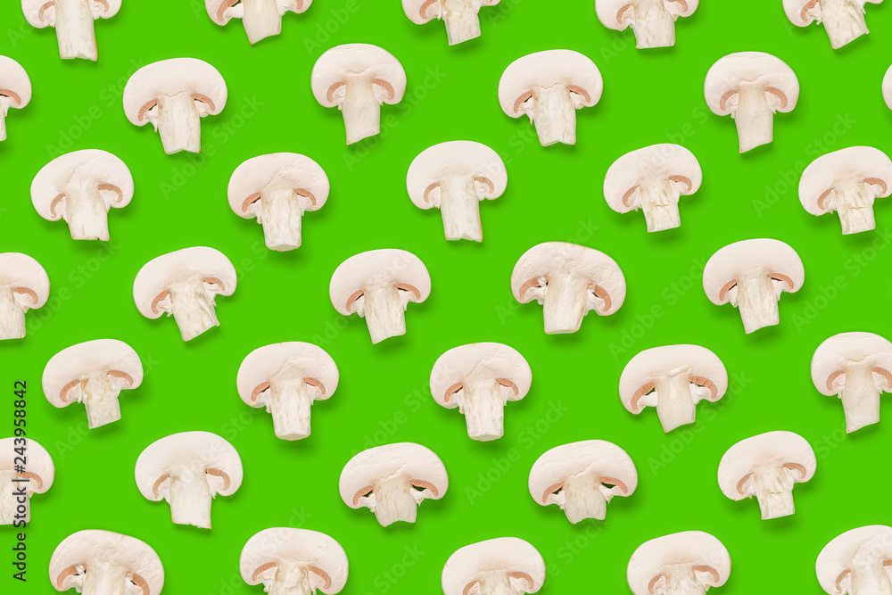 Fototapeta premium Food pattern of champignon slices on green background. Flat lay, top view. Mushroom background.