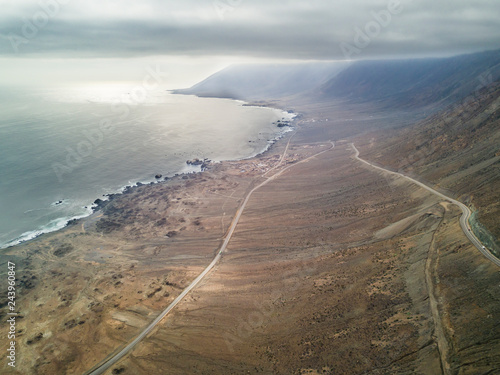 An aerial view of Paposo town and the cliffs in front of the coastline. The Camanchaca (Humidity from the sea) creates morning clouds at Atacama Desert coast area, an amazing arid and dry landscape 