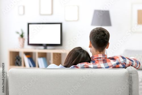 Couple relaxing on sofa wat...