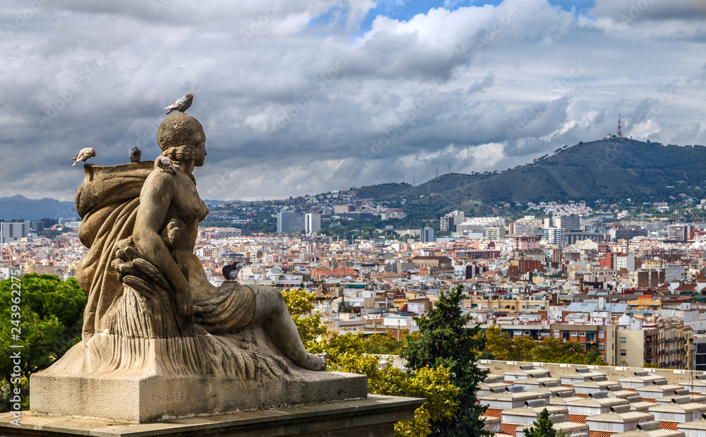Statue of a woman against the panoramic city view form the National museum of Catalan on Montjuic hill. Barcelona, Spain.