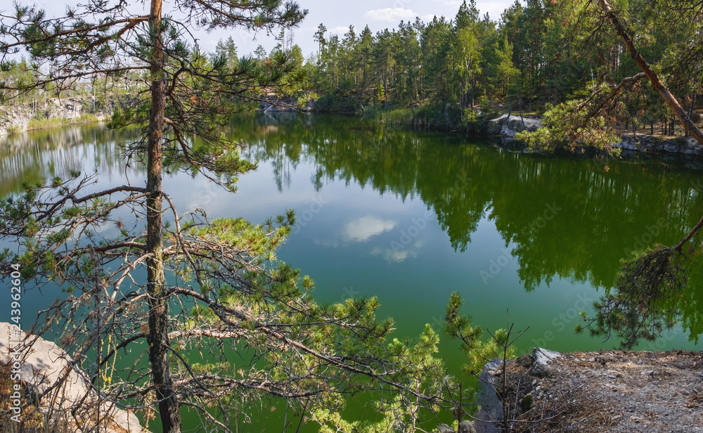 Picturesque landscape with lake and coniferous forest in Korostyshiv quarry, Zhytomyr district, northern Ukraine. Picturesque landscape with lake and coniferous forest in Korostyshiv quarry, Zhytomyr district, northern Ukraine.