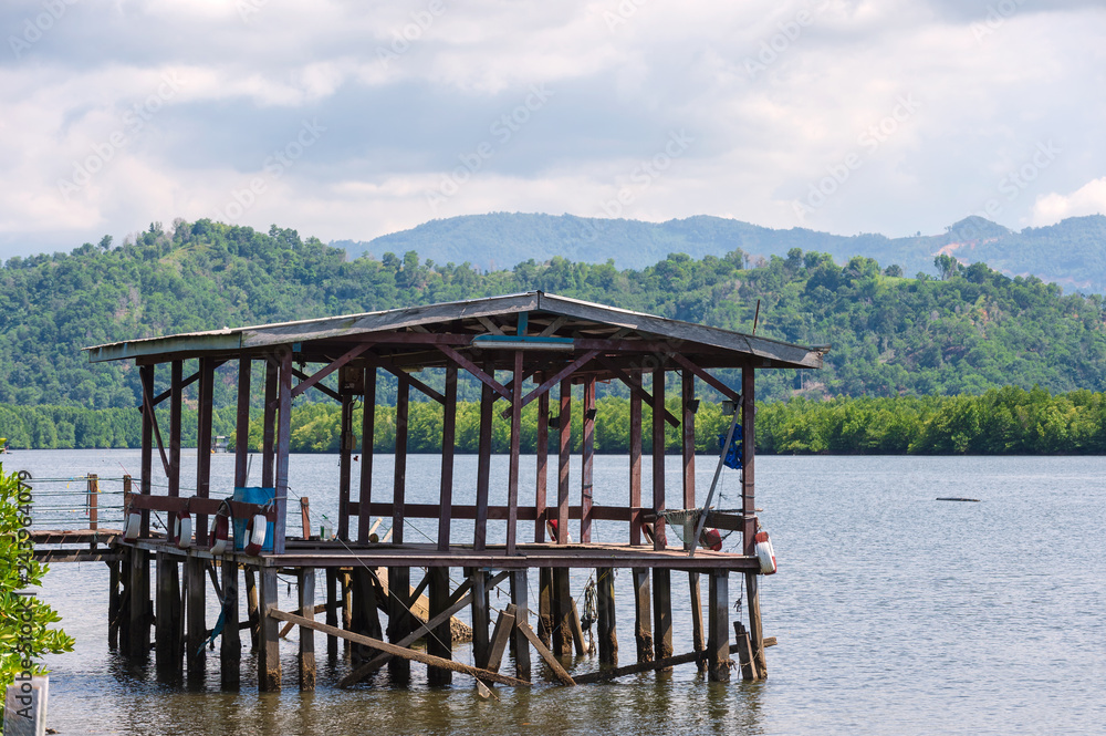 wooden structure with roof on a lake for anglers, fishermen and boats
