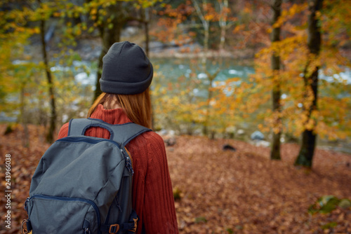 woman with backpack in the forest in yellow autumn