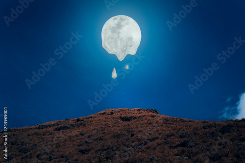 luna brillante derritiéndose sobre una montaña rocosa a la luz de la noche / paisaje de luna sobre una montaña, cerro  photo