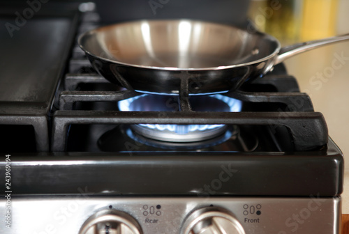 Stainless steel pan heating up on gas range stove.