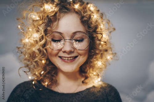 cute young girl with curls and garlands in her hair. freckles from garlands